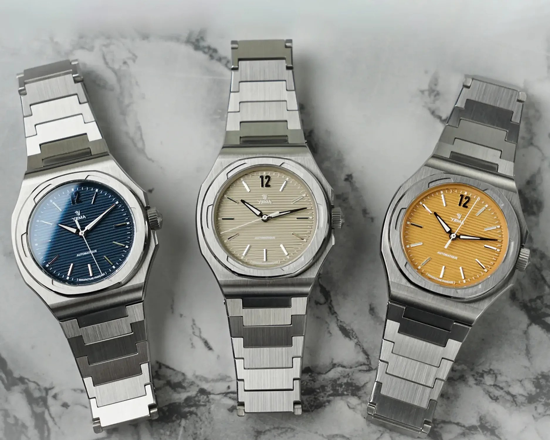 three yema sports watches on a marble table