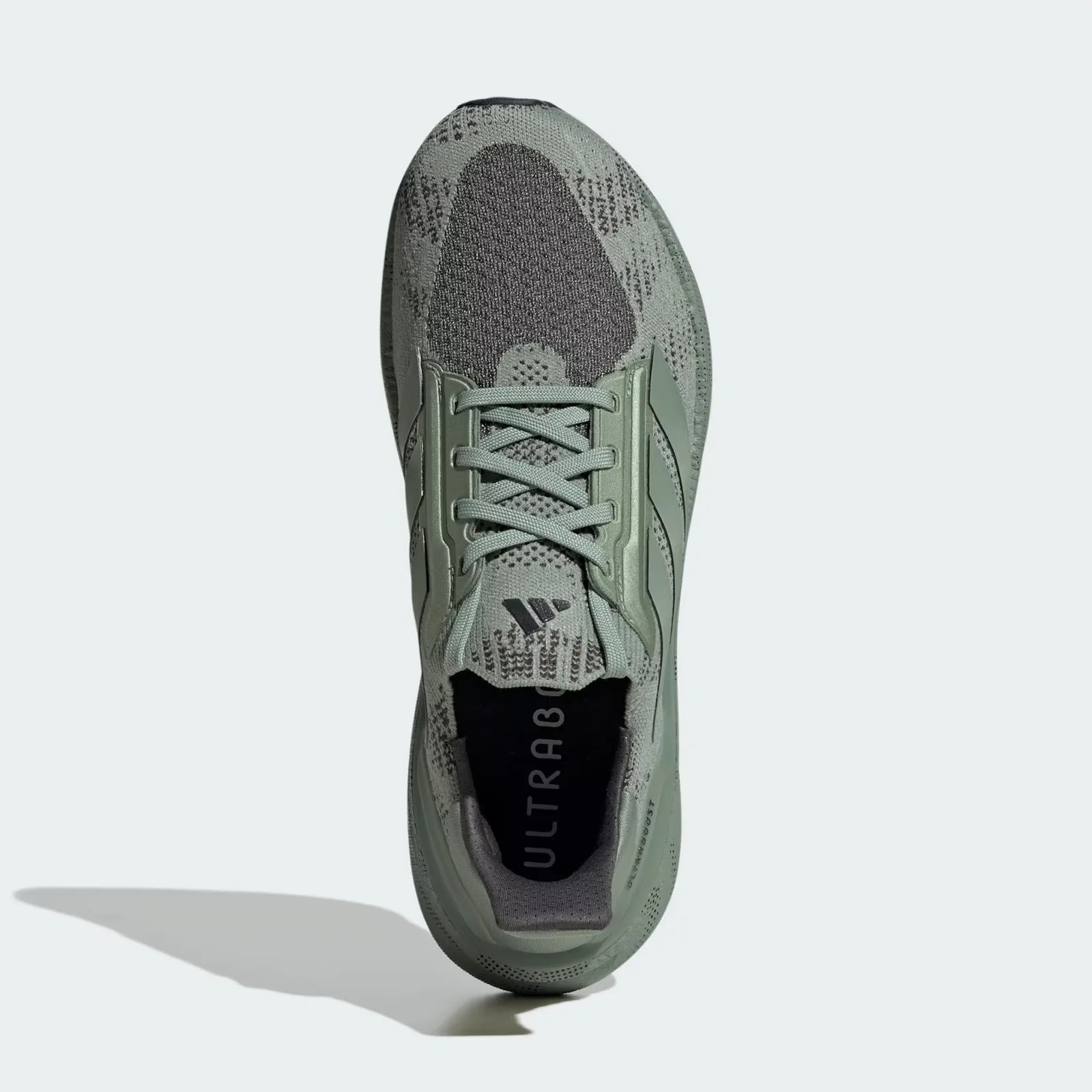 A single Adidas Ultraboost 5X shoe in silver green shown standing on its heel pointing up against a light grey background. 