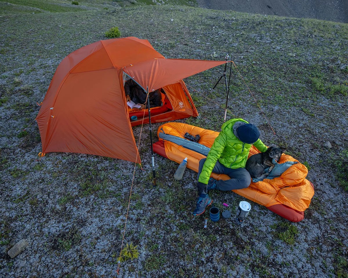 Man and dog on sleeping pad and bag outside Big Agnes Tent at campsite