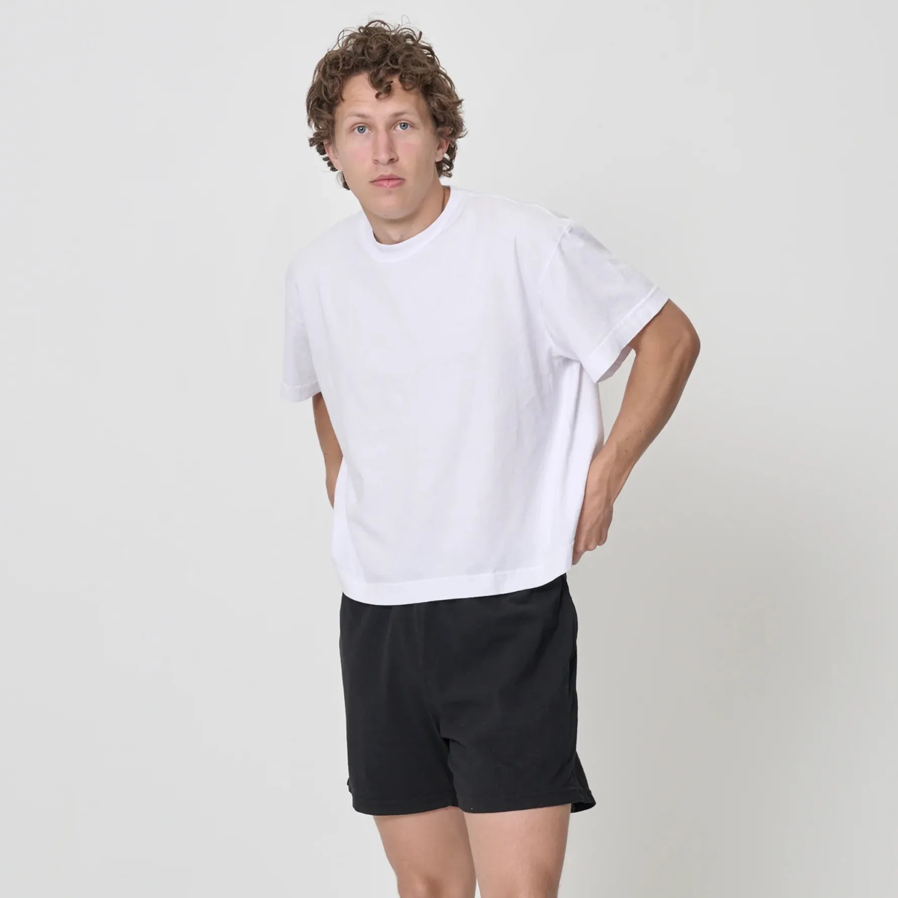 A man wearing a white t-shirt and black shorts
