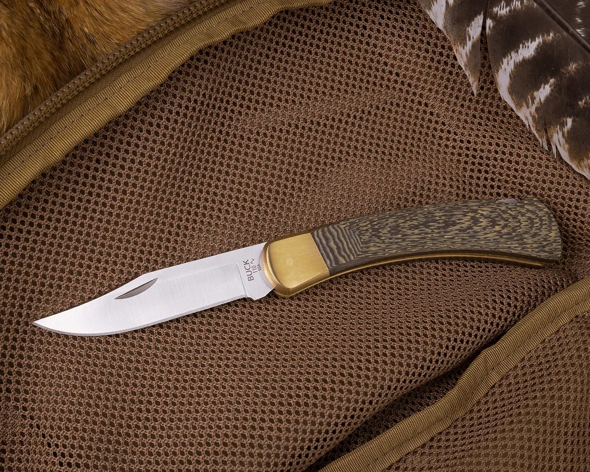 Buck 110 Folding Hunter knife on tan mesh bag