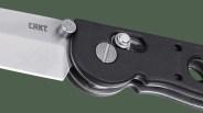 Closeup of CRKT M16 Crossbar knife pivot on green background