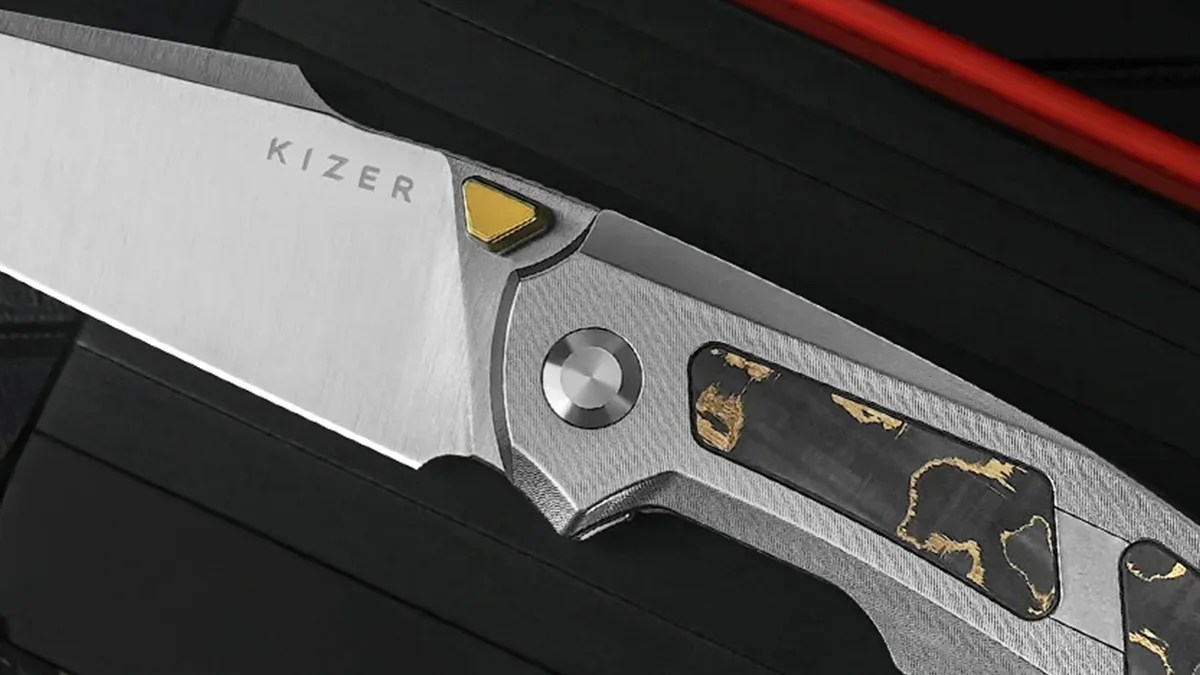 Closeup of Kizer Feweed knife on black background
