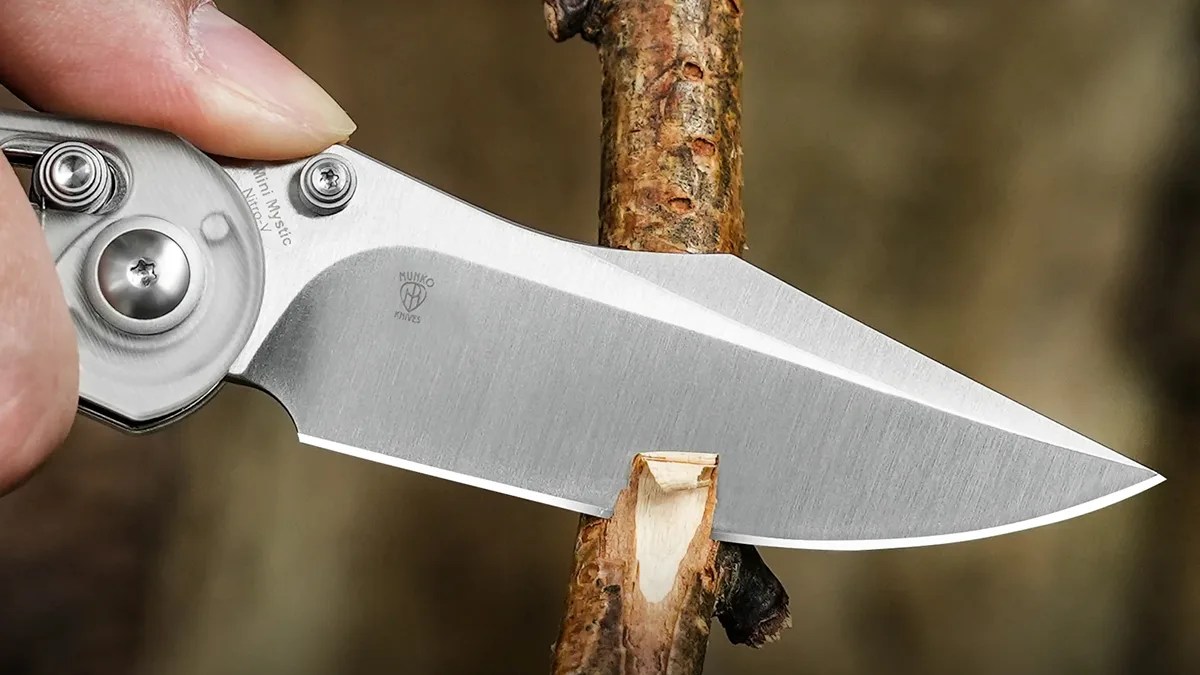 Closeup of Kizer Mini Mystic blade cutting through branch