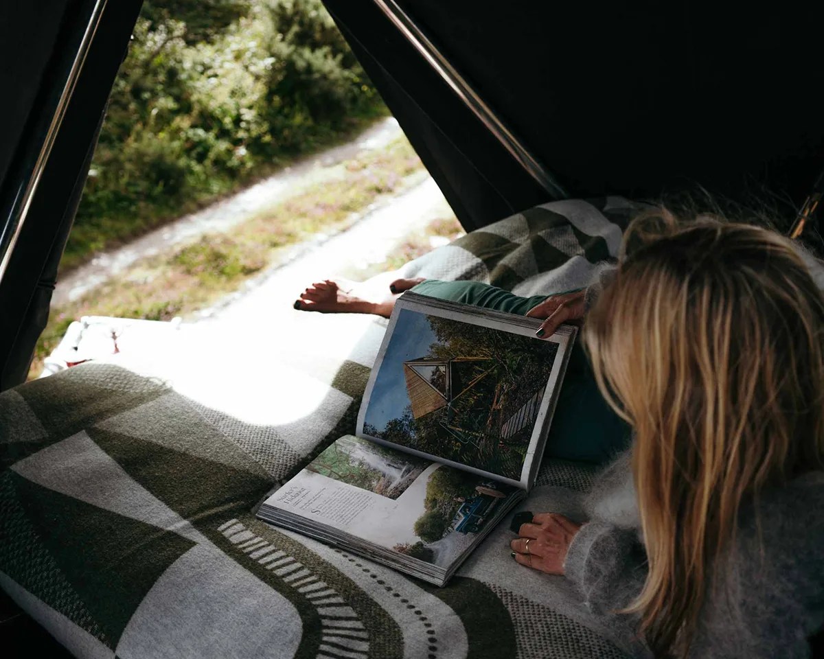Woman reading architectural book inside Kudhva Kanvas 001 K-Tent