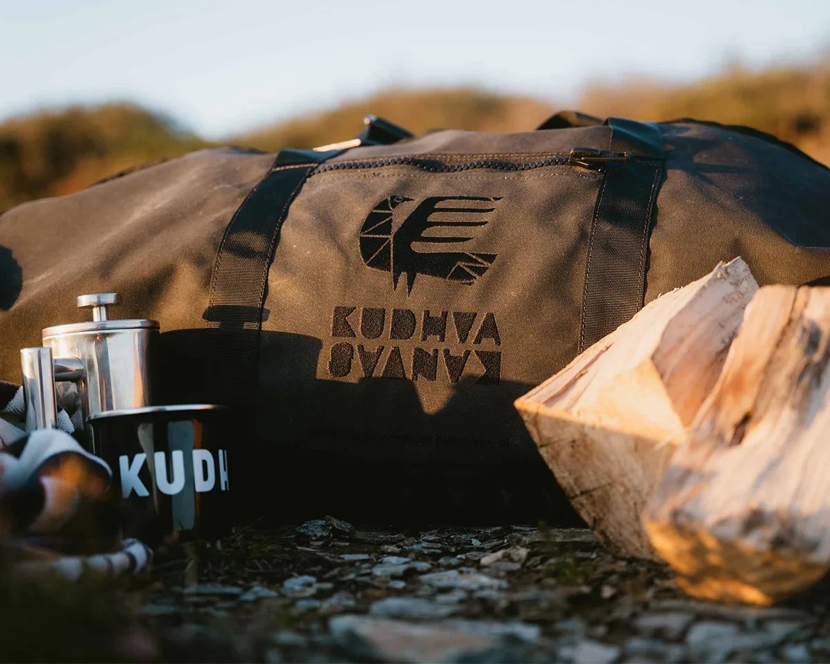 Kudhva Kanvas 001 K-Tent in travel duffel next to coffee kit and wood logs