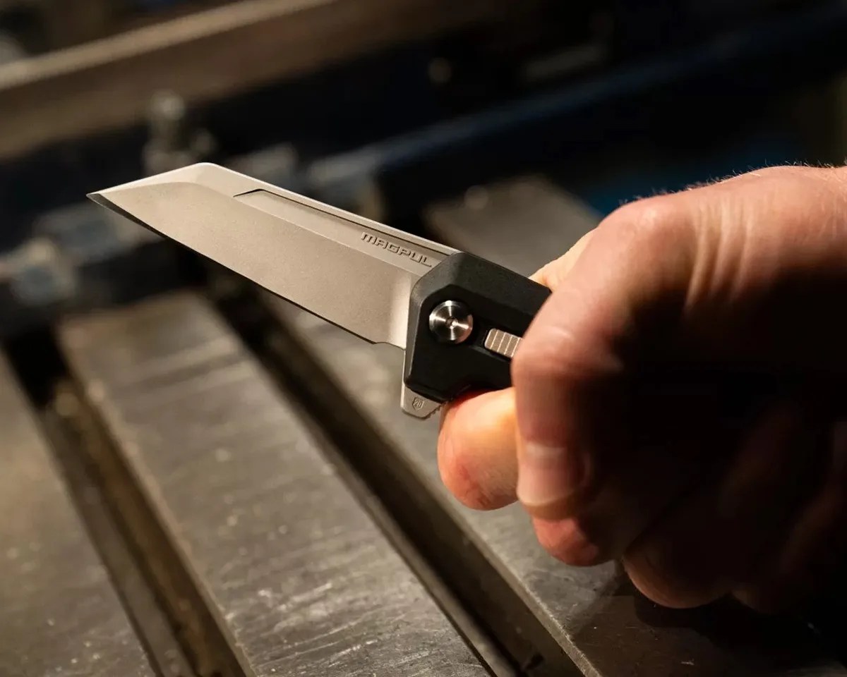 Magpul Breslau knife in hand in front of machinery