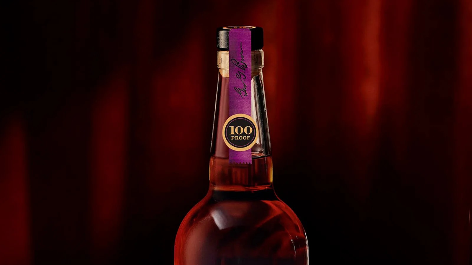 The neck of a bottle of Old Forester 1924 Bourbon shown against a blurred velvety brown background. The neck features a bright purple label with a black circular sticker that says "100 proof"