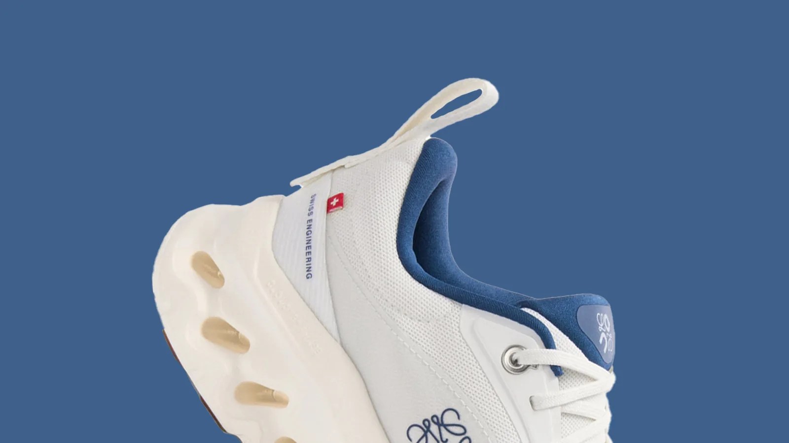 The a close up of a heel of Loewe x On's collaborative Cloudtilt 2.0 sneaker in blue shown against a blue background