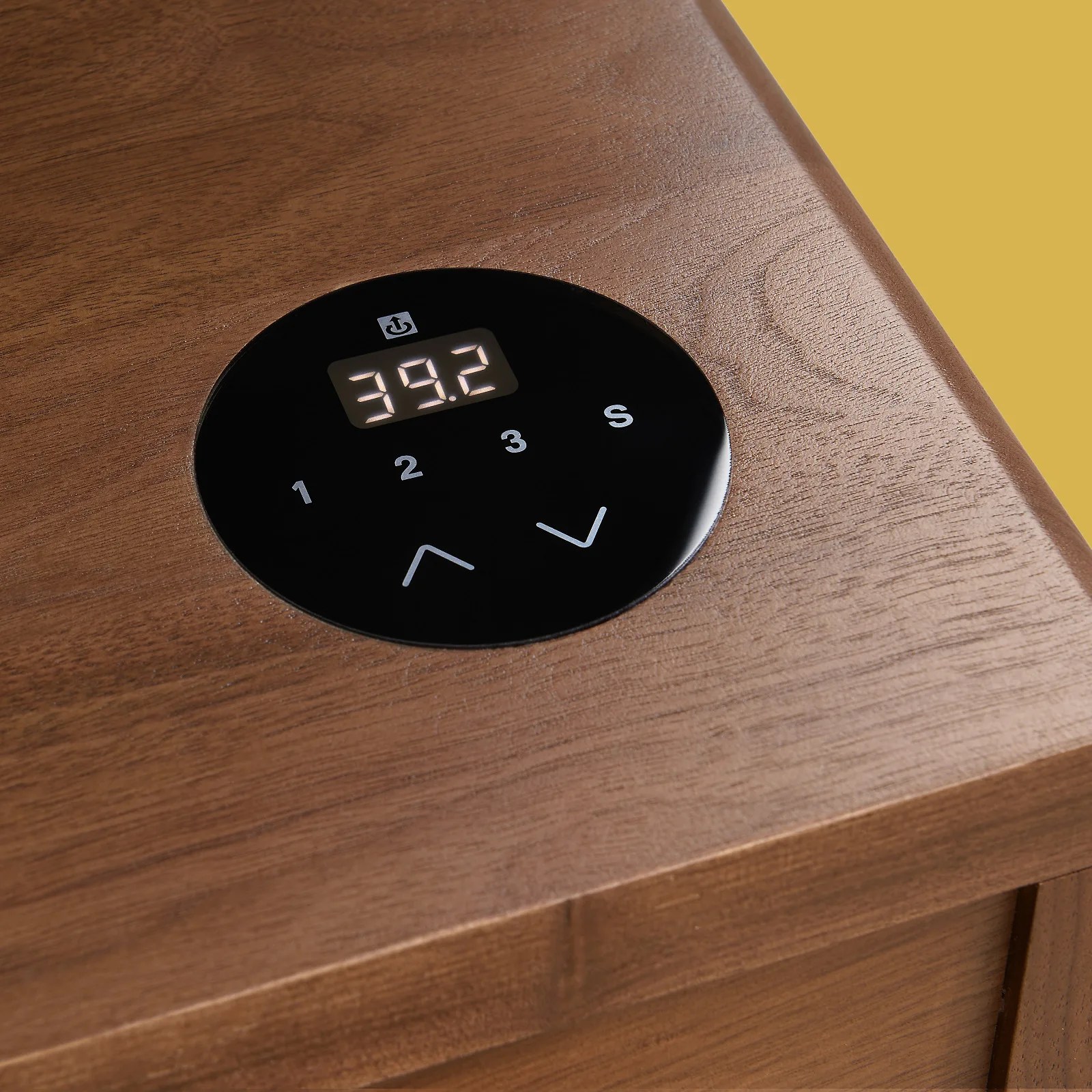 A closeup view of the touch control panel embedded in the lower right corner of Room&Board's Lincoln standing desk. The panel shows the desk surface's height in the digital display, as well as four numbered buttons below it and two up and down arrows below that.