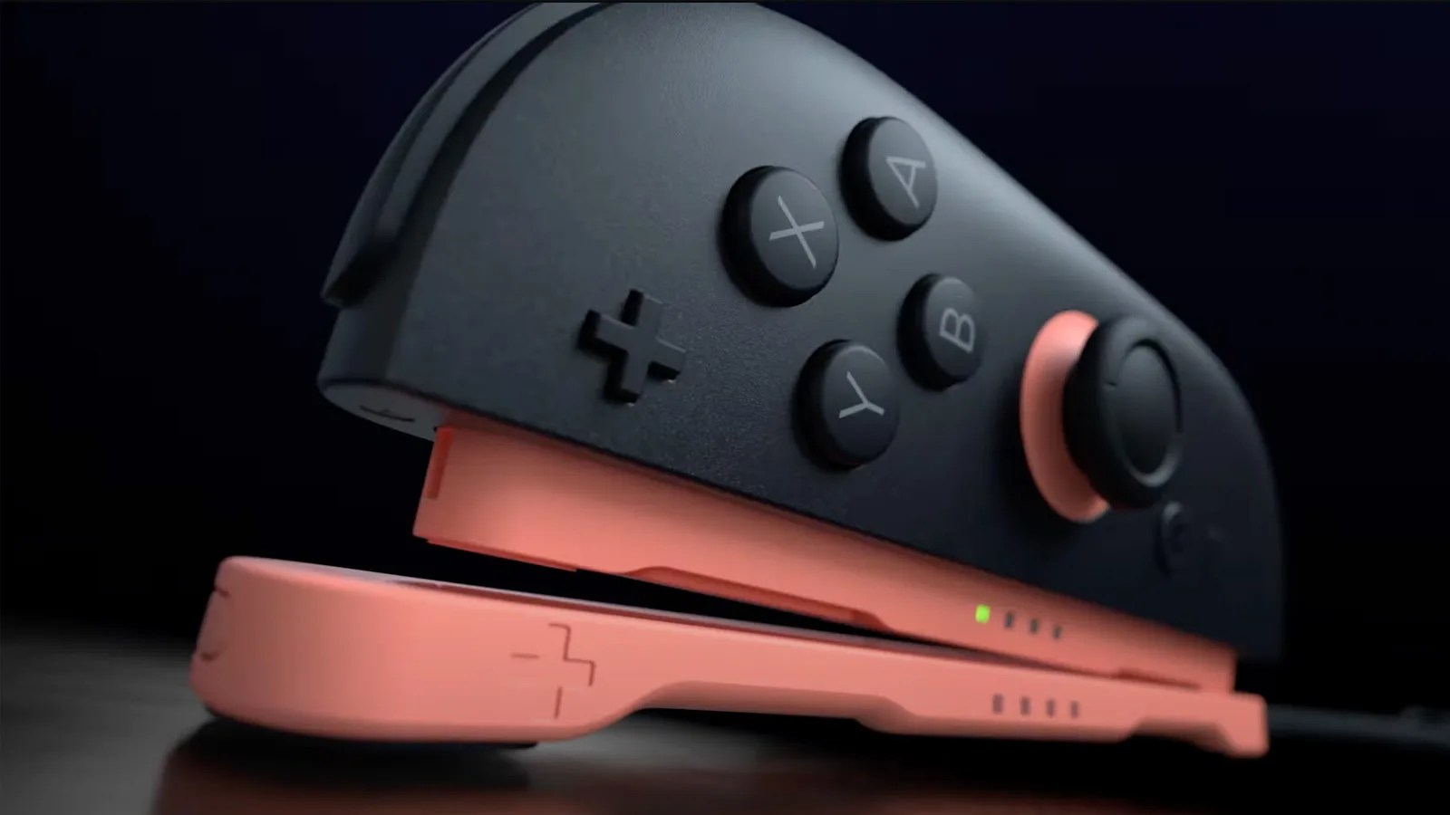 A Nintendo Switch 2 right side joy-con shown snapping into a large pink plastic piece laid flat against a surface. 