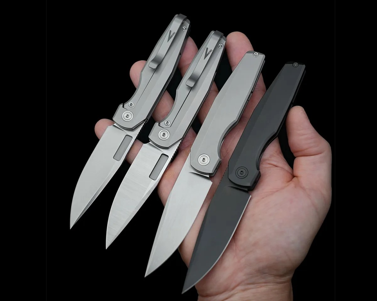 Vero Engineering 3.3 knives in a person's hand on black background