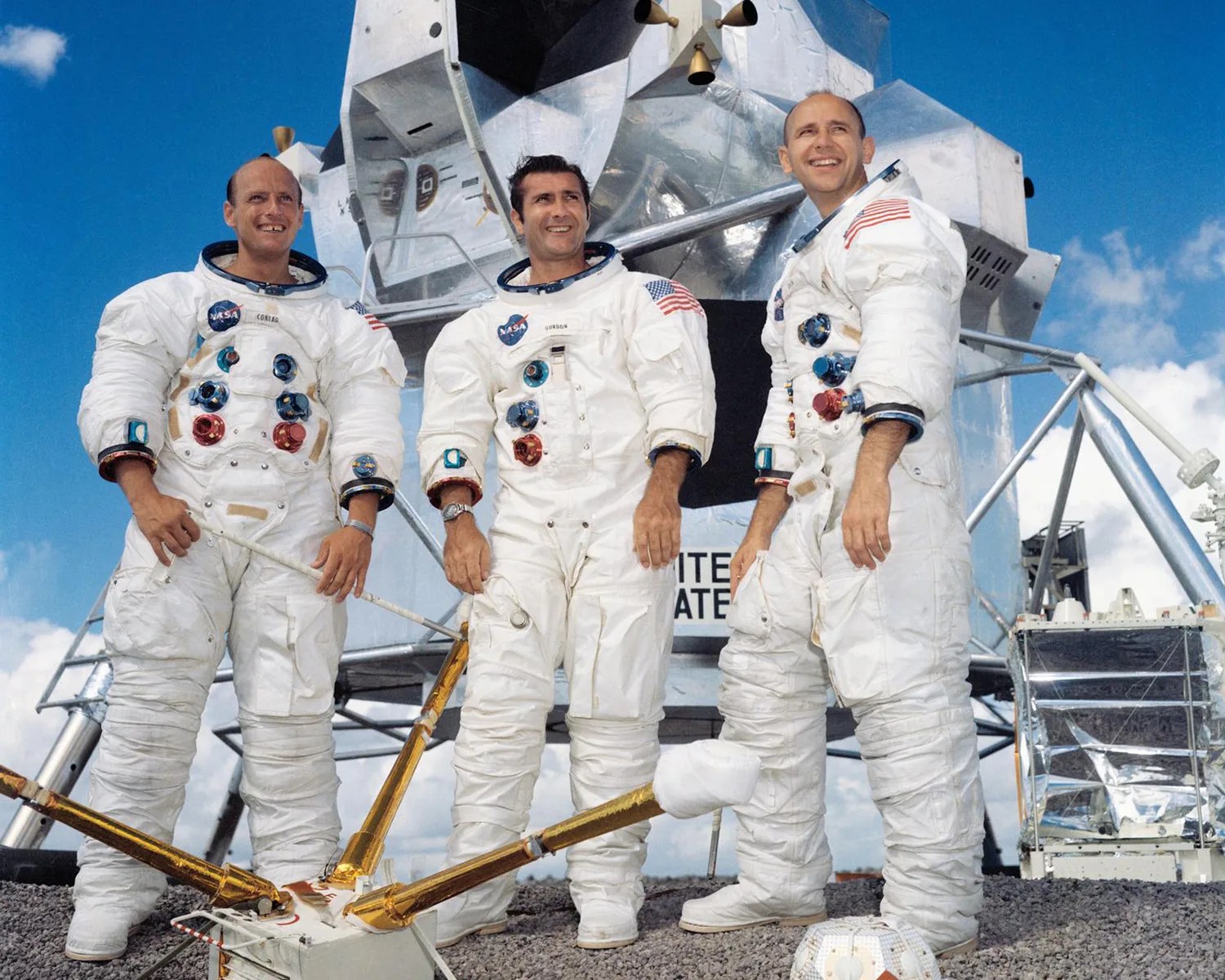 three nasa astronauts from the apollo 12 mission pose in front of a lunar module
