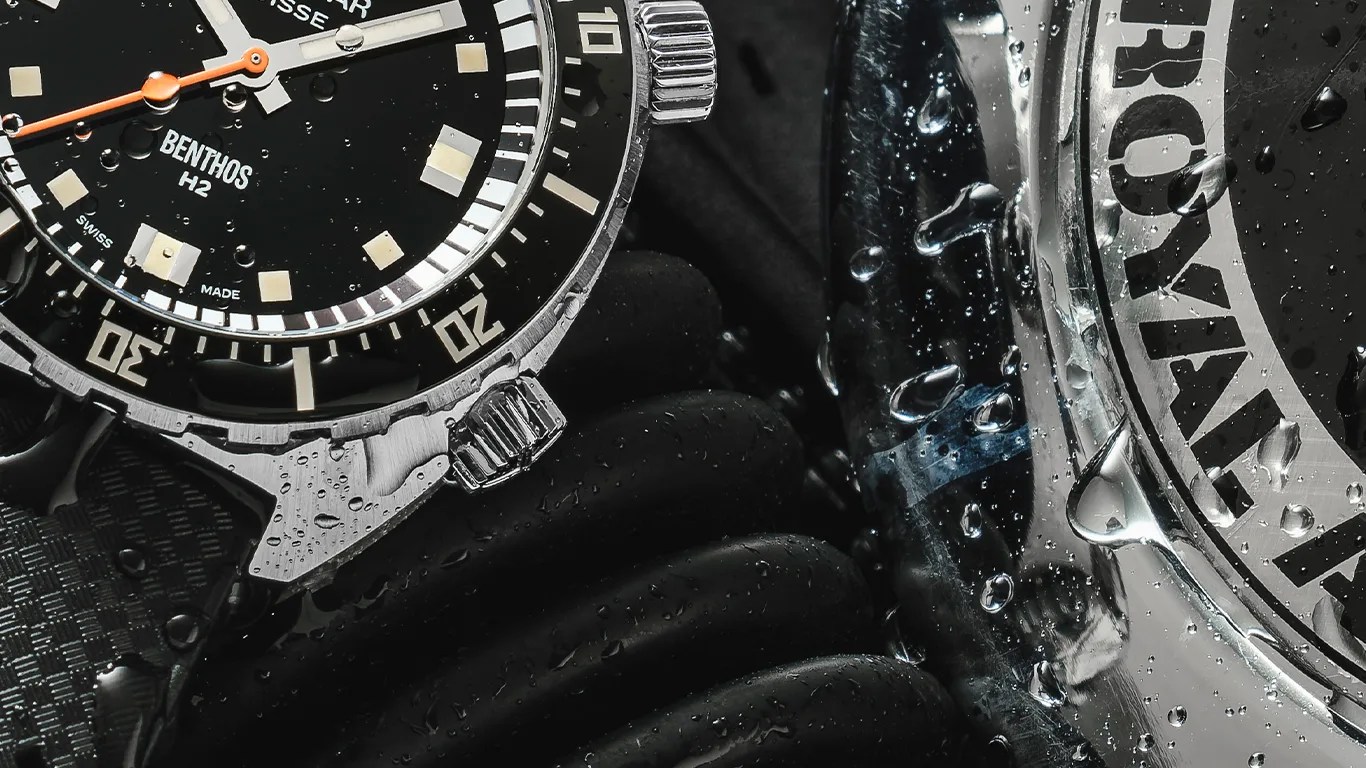 a closeup of an aquastar dive watch with some wet diving equipment