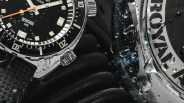 a closeup of an aquastar dive watch with some wet diving equipment