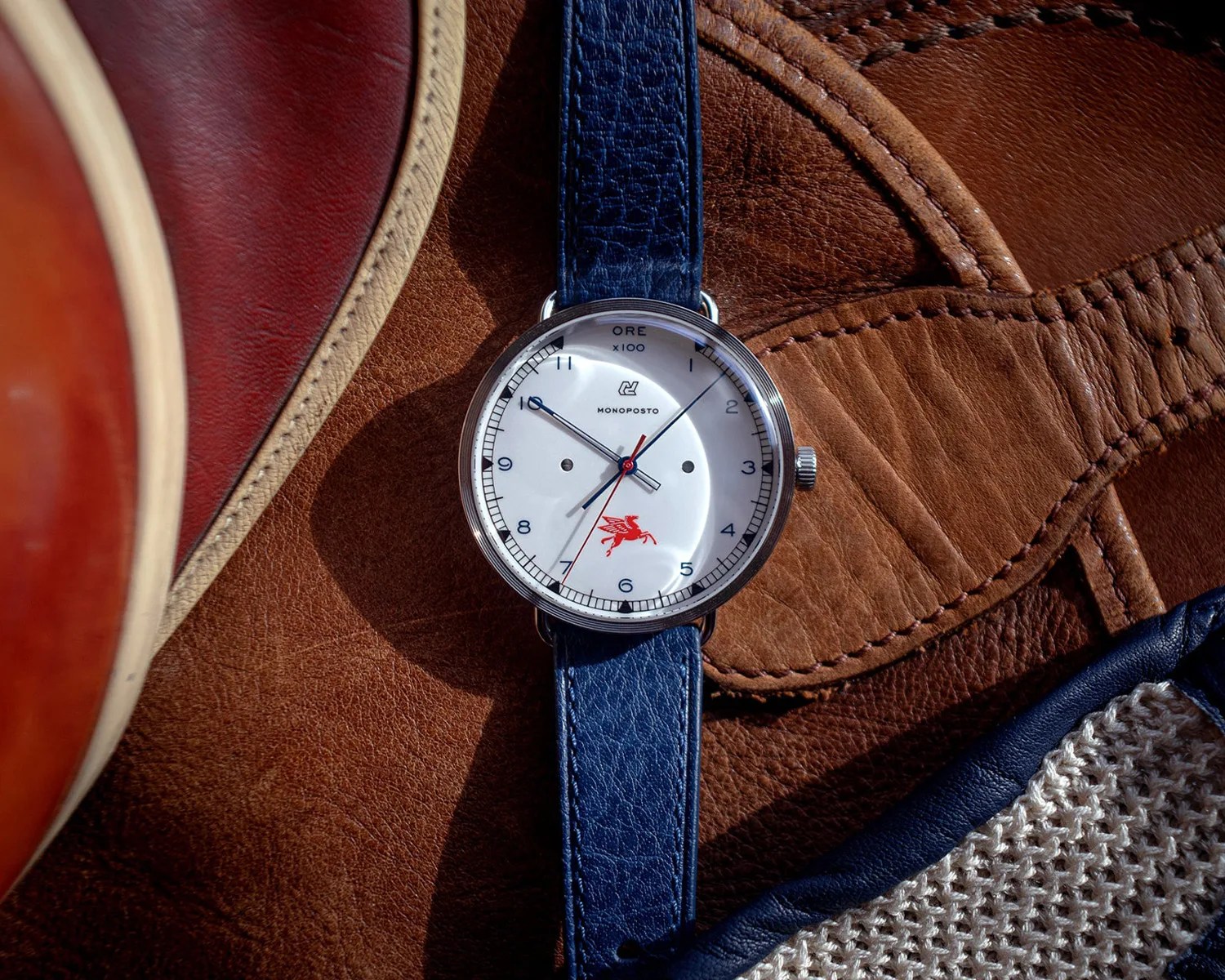an autodromo watch next to some driving gloves and leather