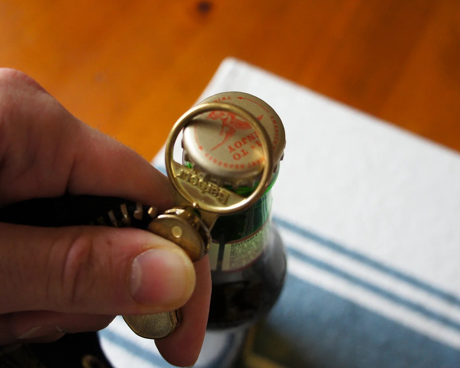 a closeup of a barbour jacket zipper being used to open a bottle