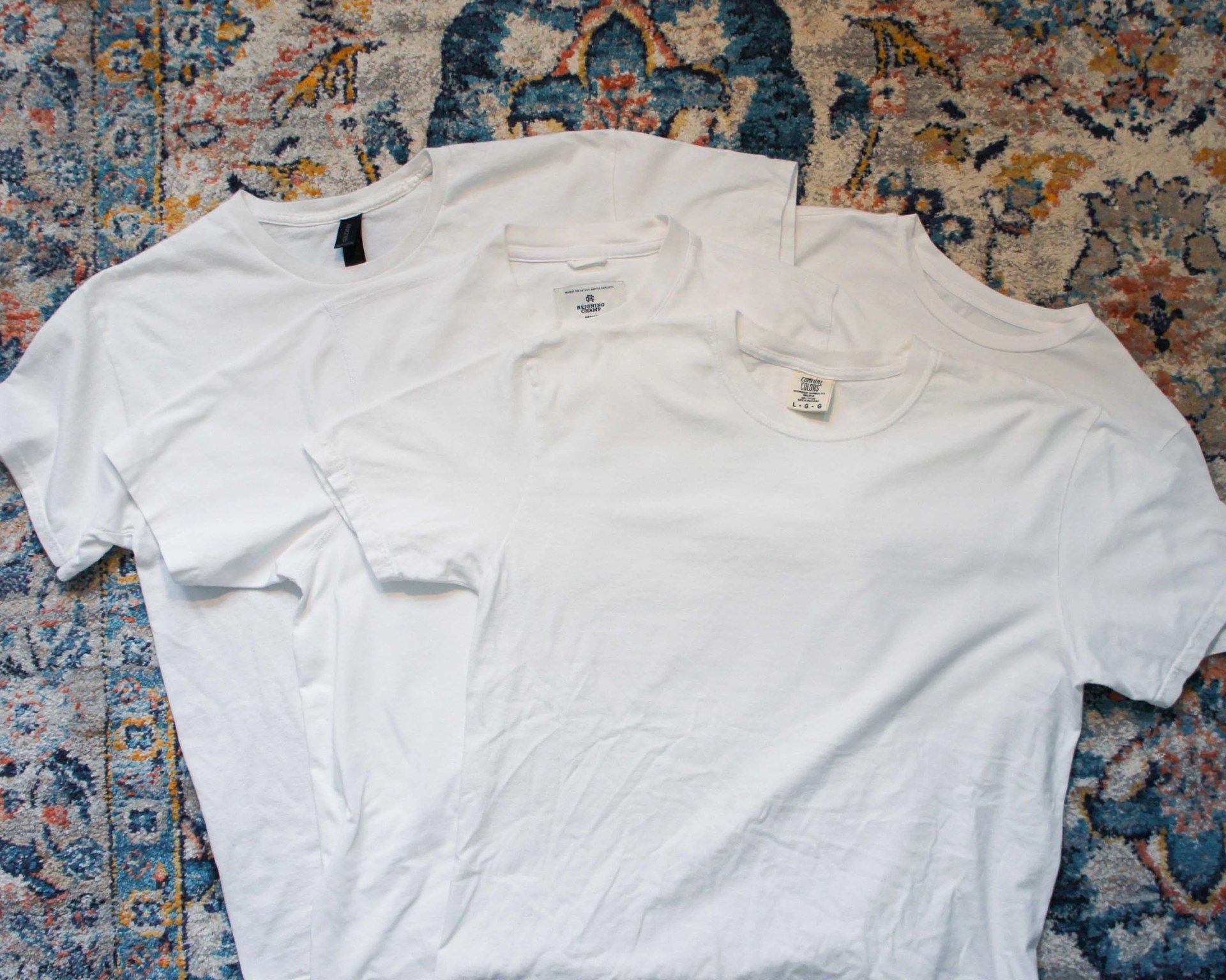 four t-shirts laying on a Persian rug