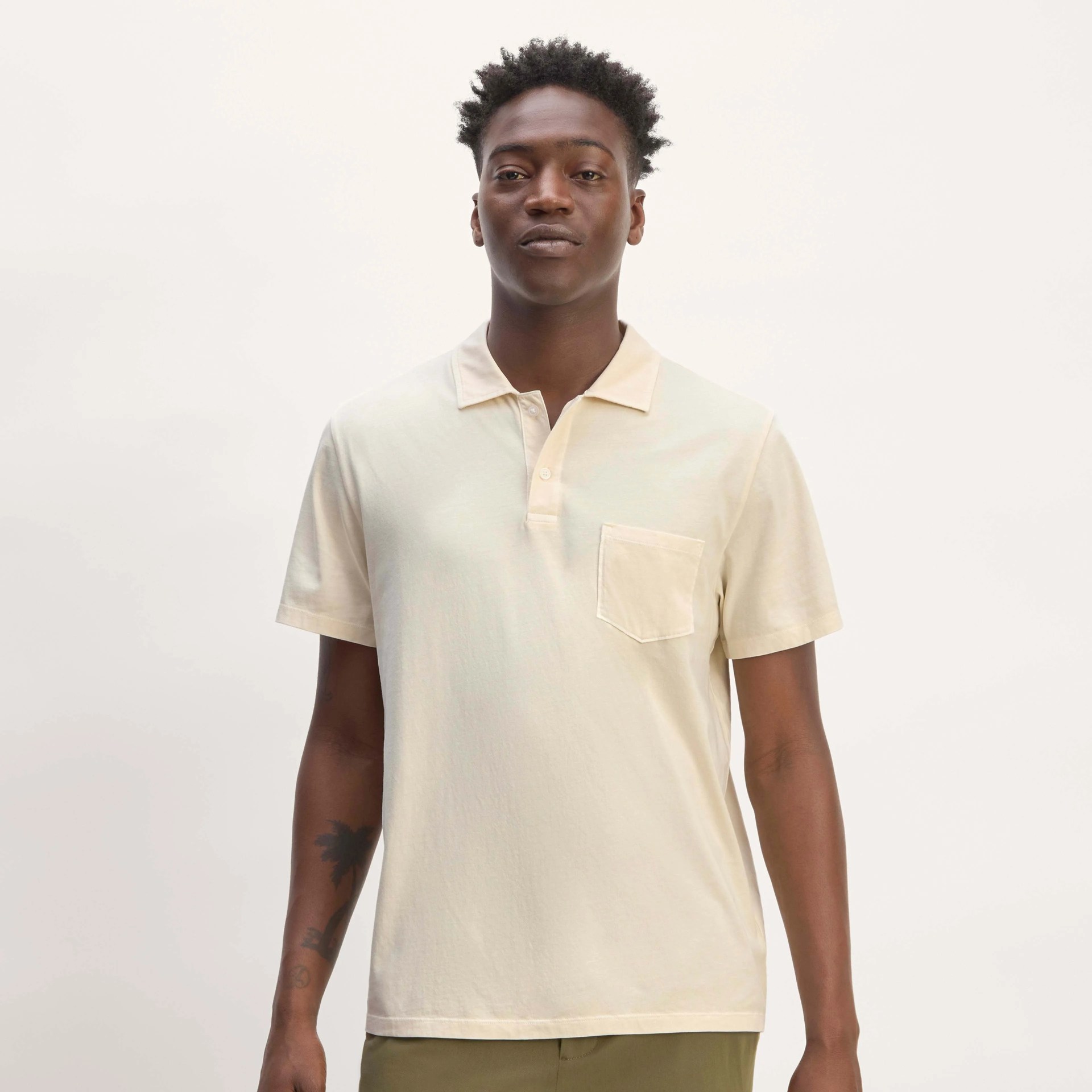 A man in a cream colored polo shirt