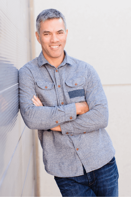 A photo if "Inner Excellence" author Jim Murphy with his arms crossed learning against a wall