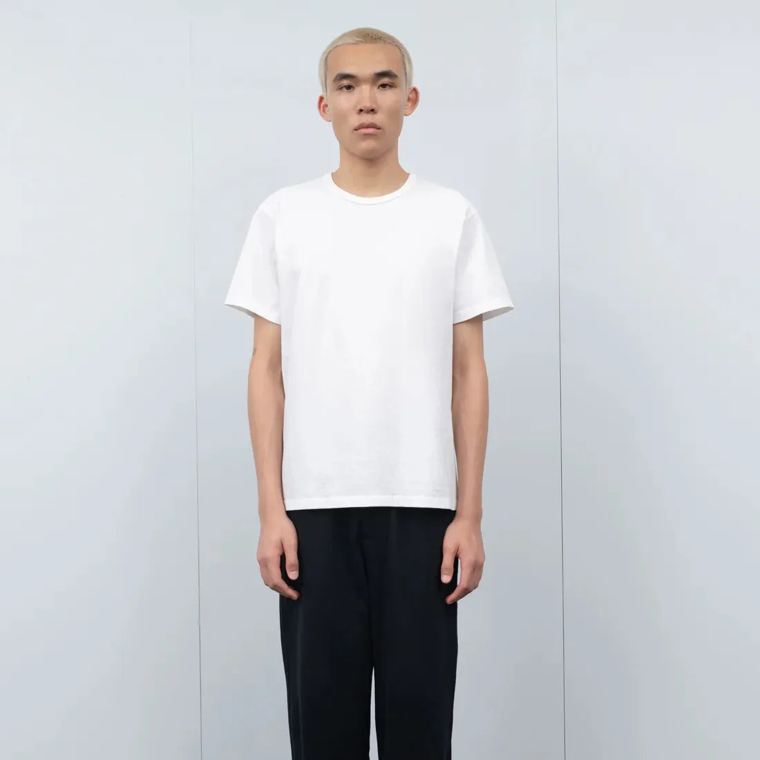 a man wearing a white t-shirt and black pants