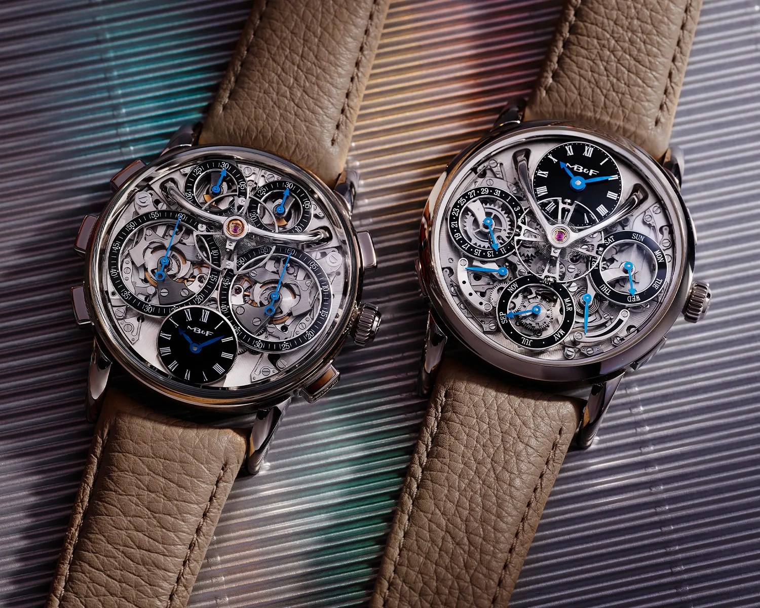 two mb and f watches next to each other