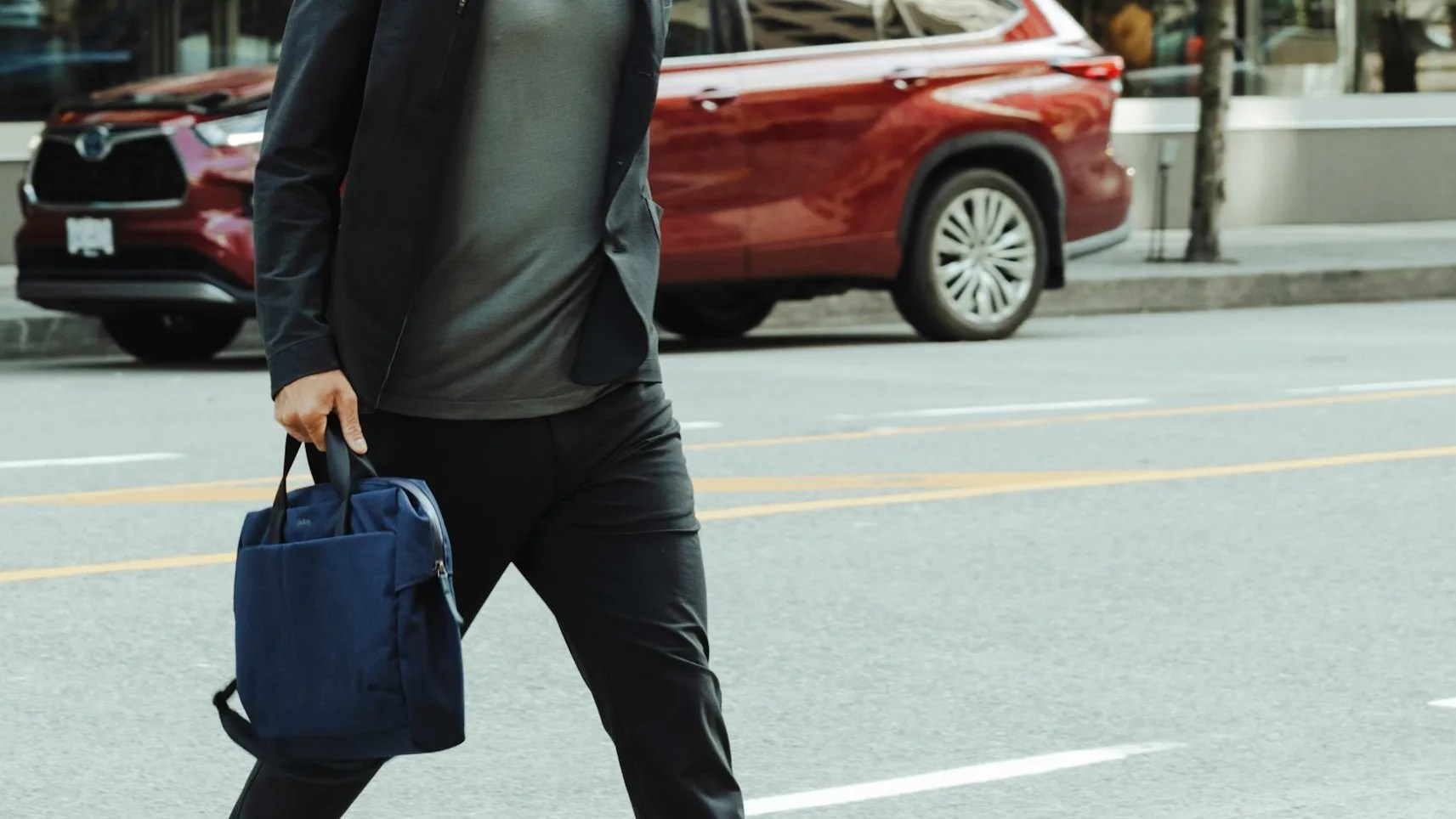 A man crossing a street with a briefcase