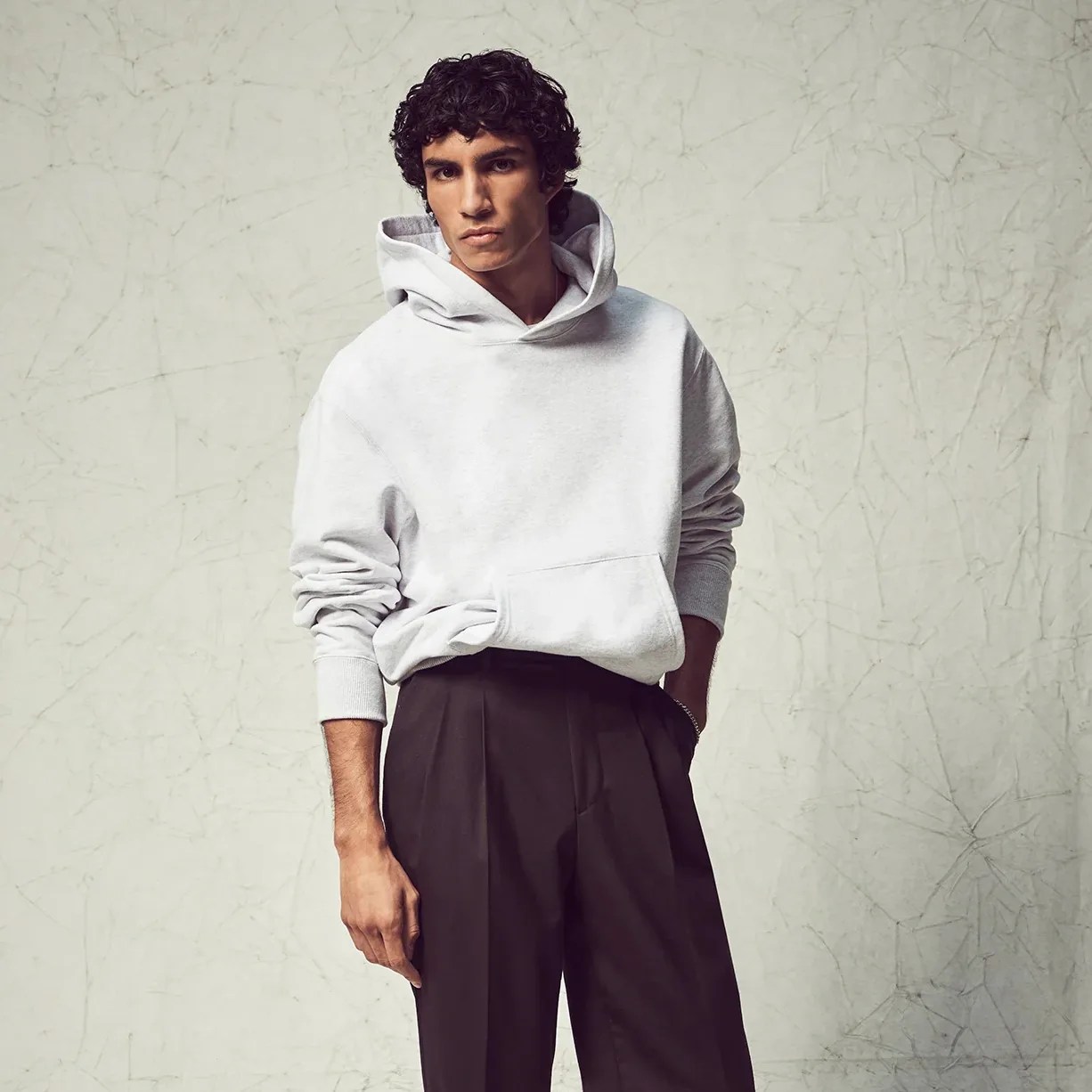 a man wearing a hoodie and dress pants