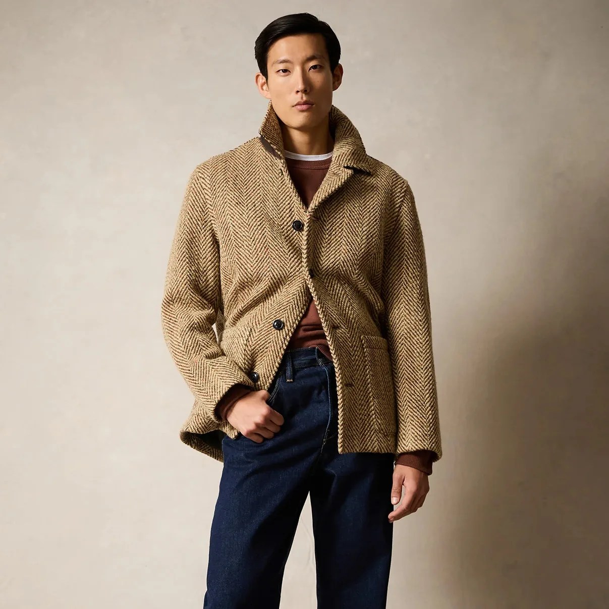 A man wearing a brown herringbone jacket