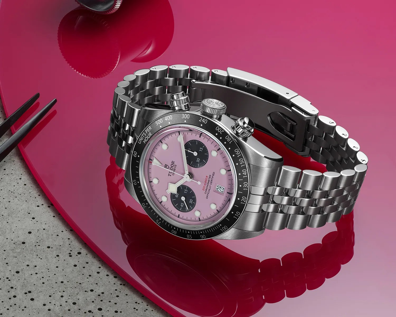 a pink tudor chronograph watch on a work bench