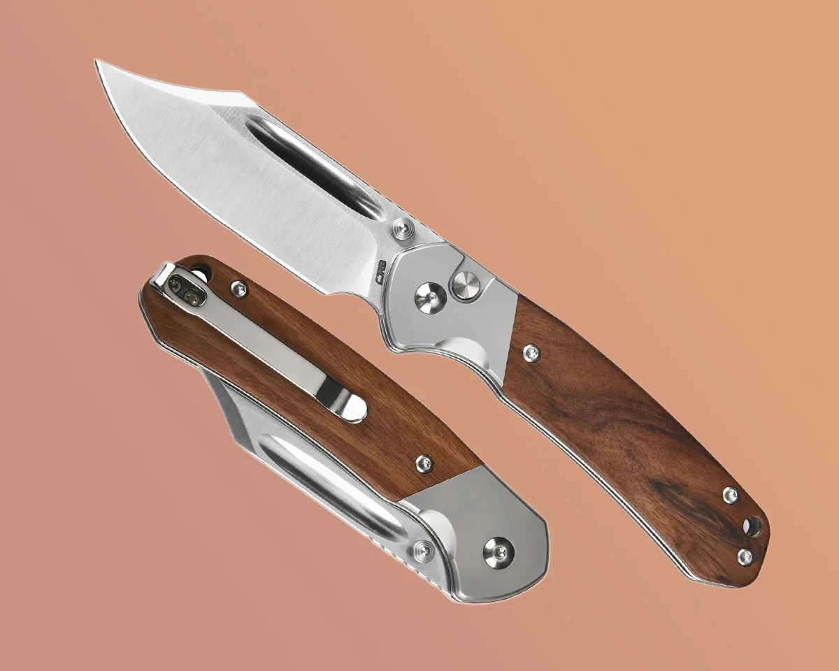 Two CJRB Bowie Pyrite knives on a sand-colored background