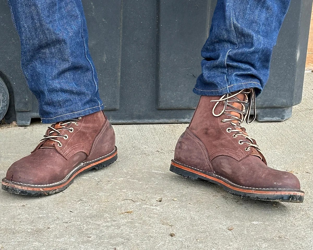 Nicks Handmade Boots Strider Zero Drop Work Boot worn by person in blue jeans on concrete in front of plastic container