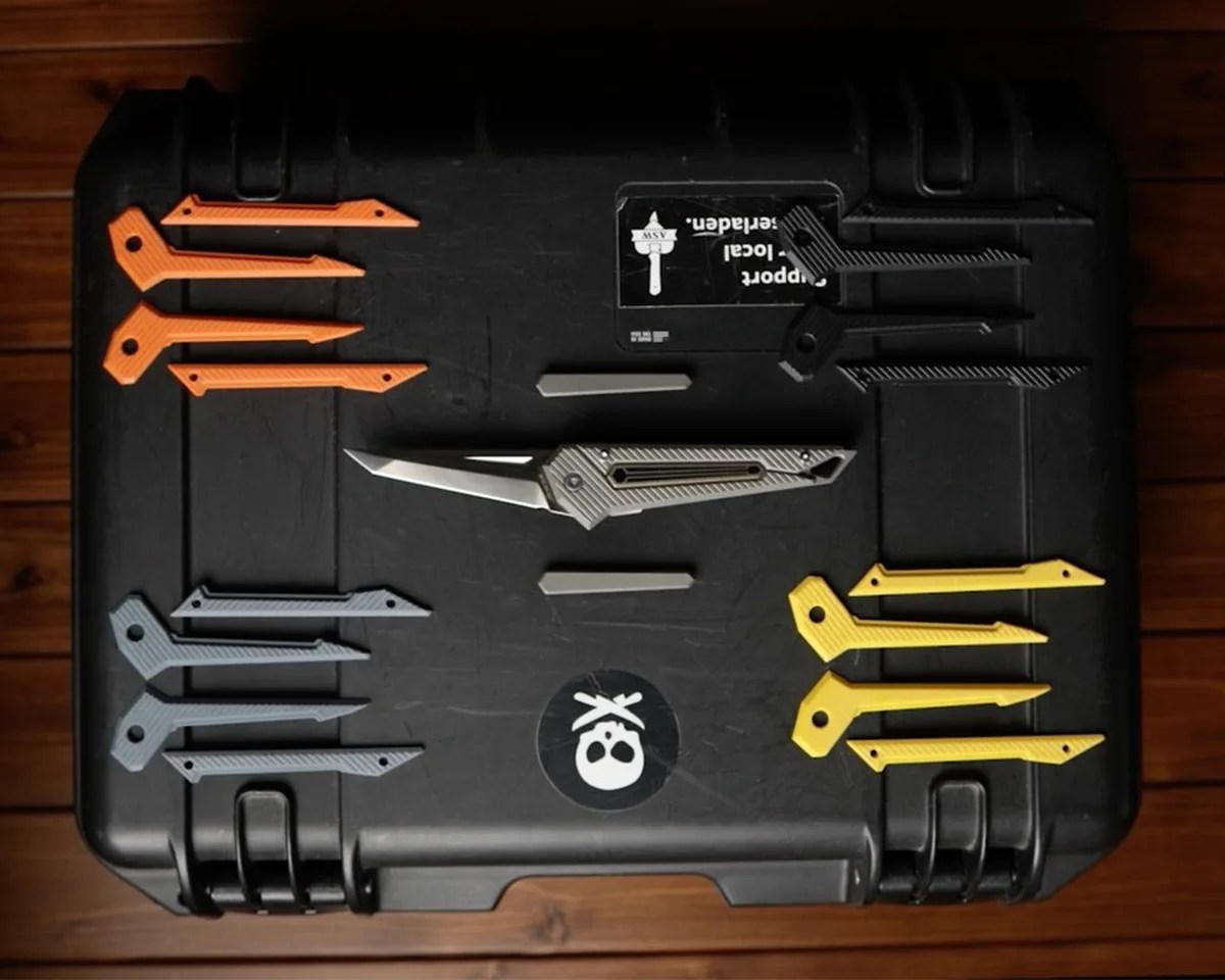 Pichi Design Kameta knife on tough storage box surrounded by handle scale options