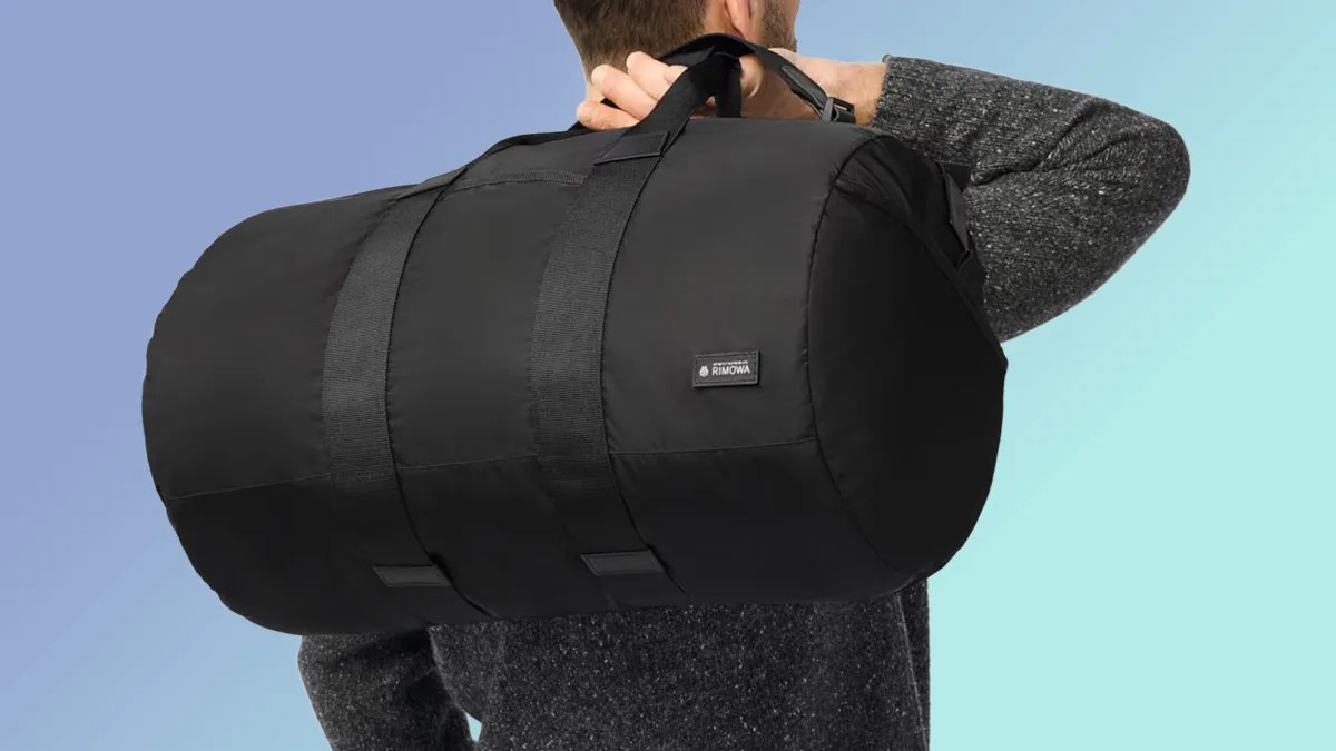 Rimowa Foldable Gym Bag in man's hand on blue background