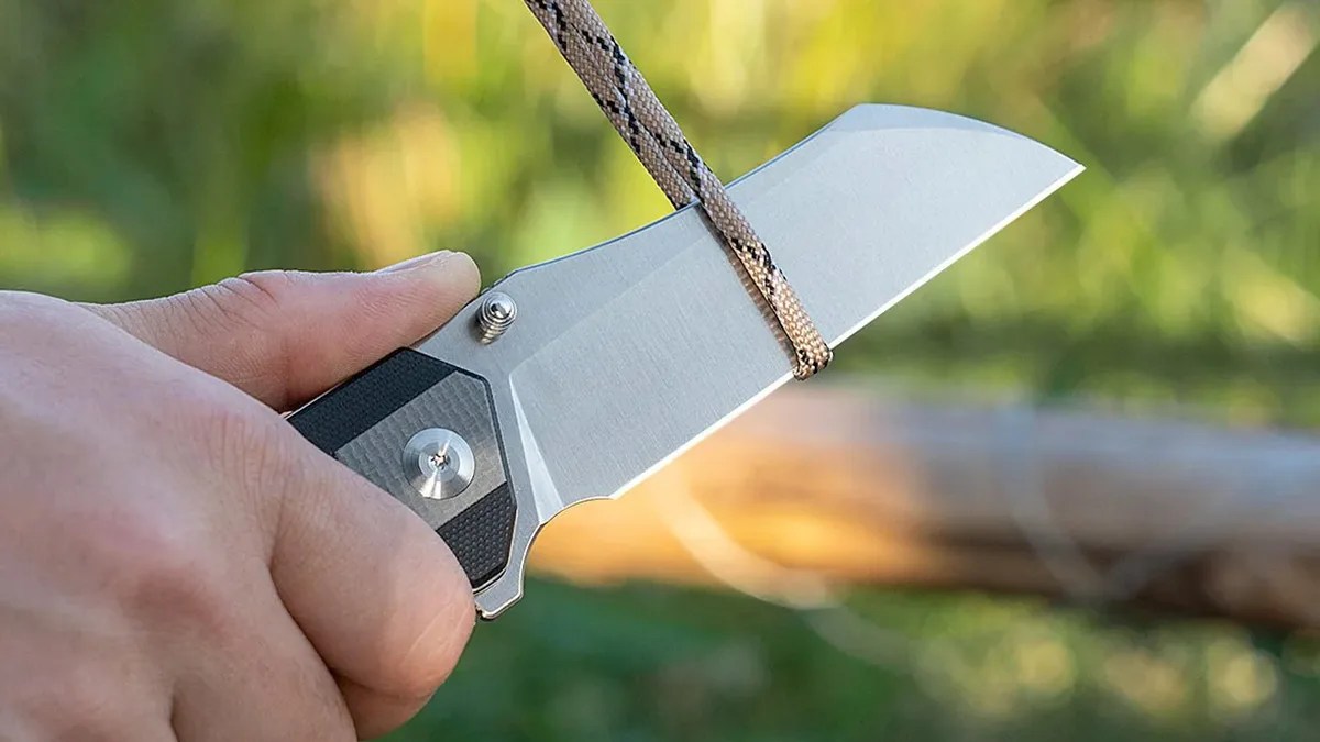 Closeup of Sencut Draxor knife cutting through paracord