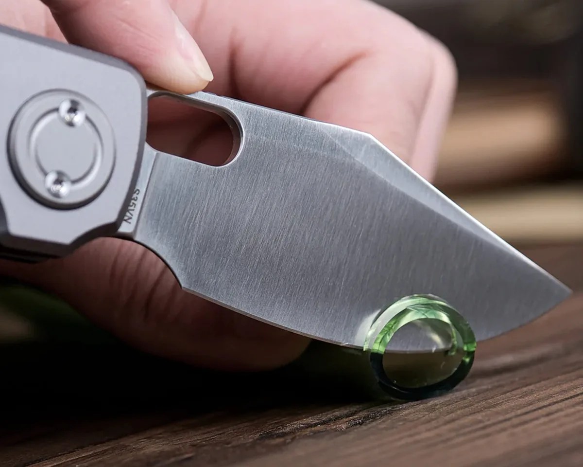 Vosteed Akita knife cutting rubber tube closeup