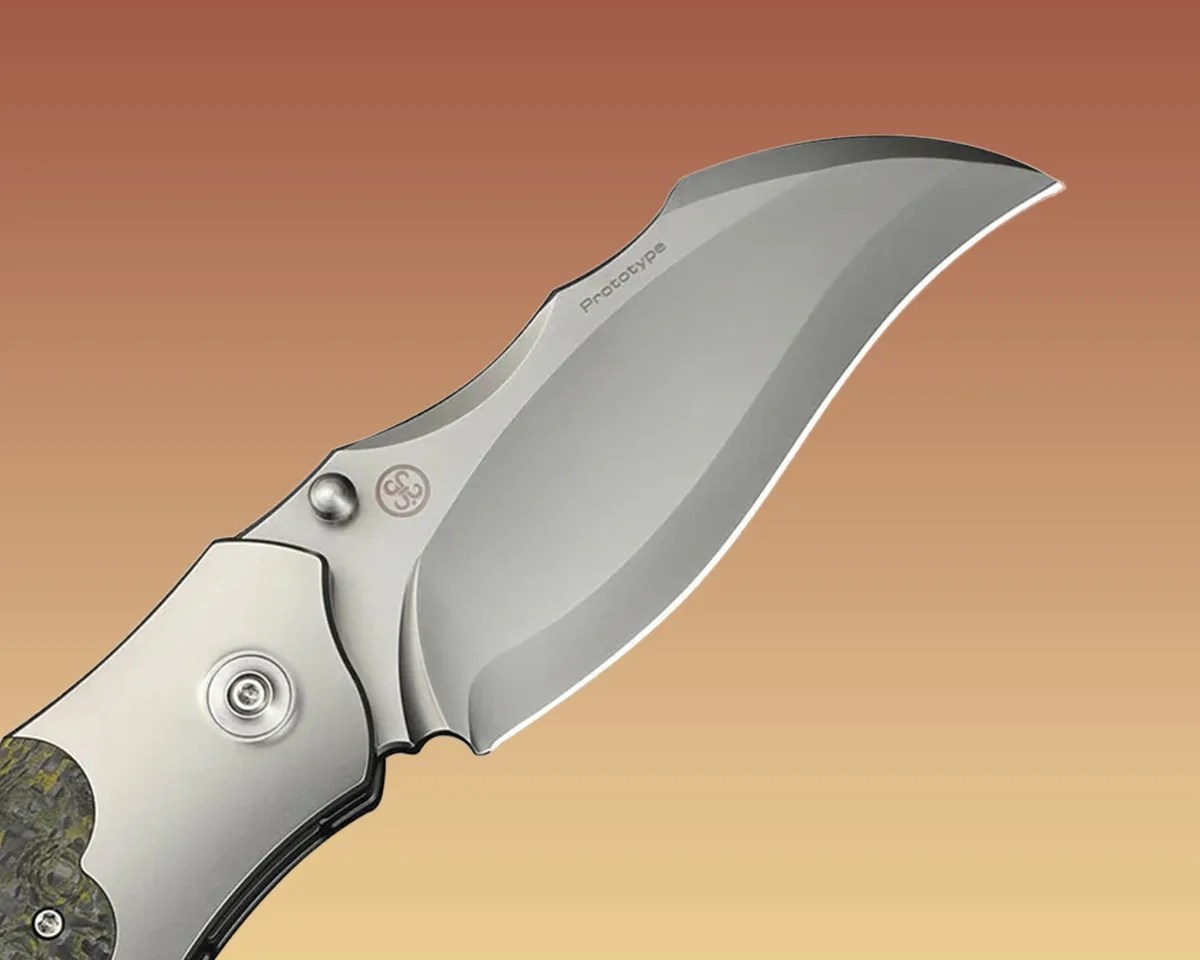 Closeup of We Knife Orc Boss knife blade on yellow-brown background