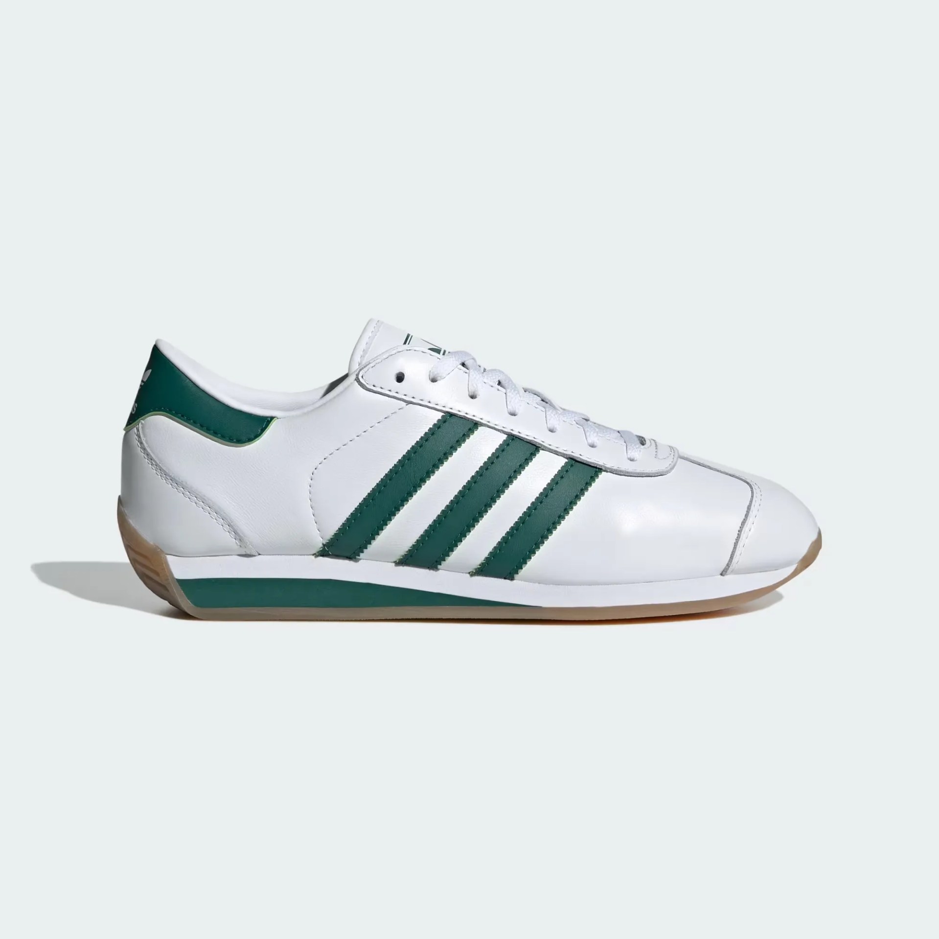 A pair of white Adidas leather sneakers with green details.