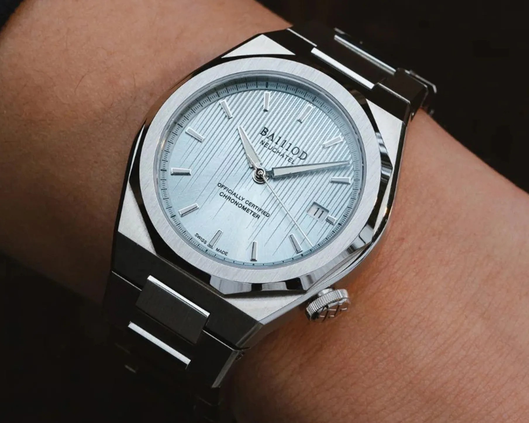 a silver watch with a light blue dial