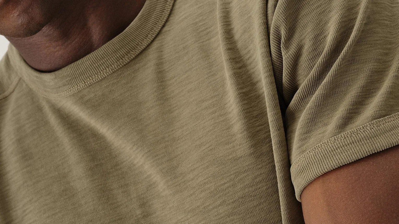 Close up of the upper chest of a green Buck Mason Sidewinder Rib Ringer Tee