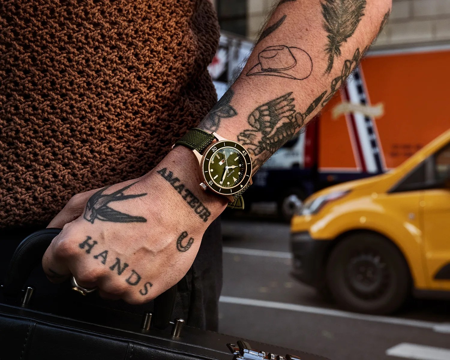 a bulova dive watch on a tattooed man wrist
