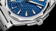 the bezel and case of a steel watch with a blue dial