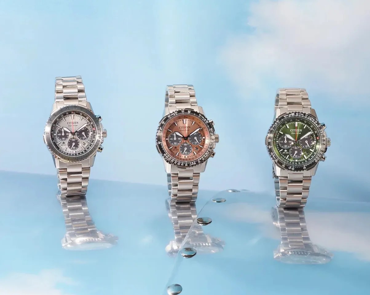 three citizen chronograph watches on a silver panel set against the sky