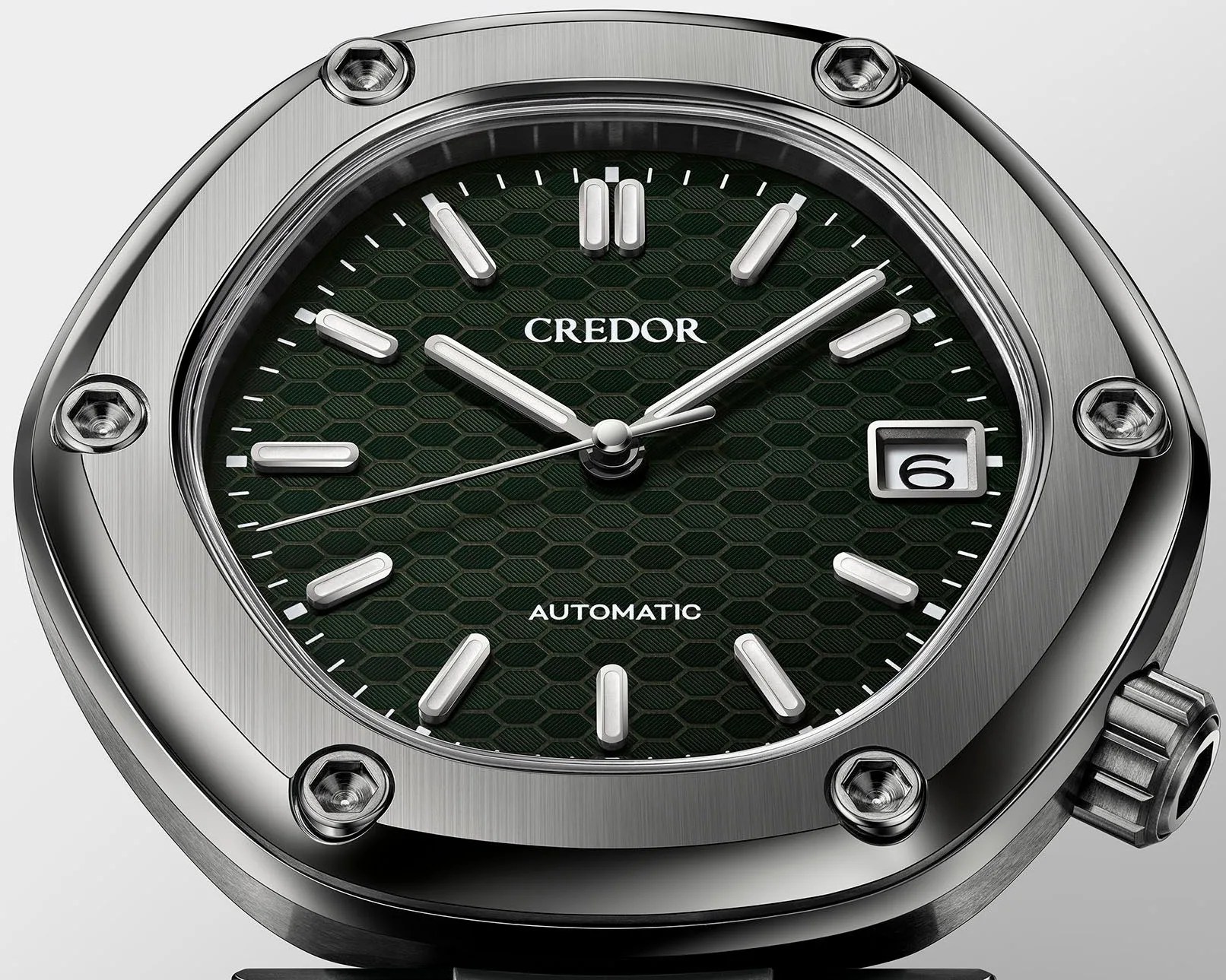 a silver watch case with a green dial