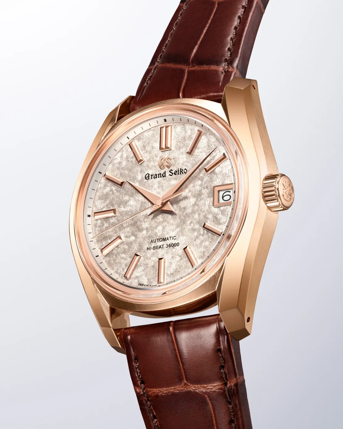 a gold grand seiko watch with a brown leather strap