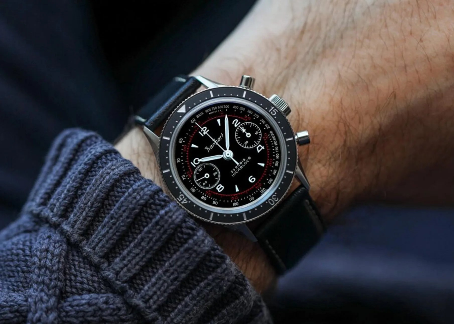a black chronograph watch on a man's wrist