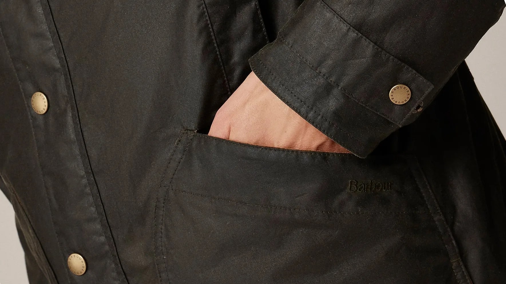 close up of man's hand in the pocket of his green jacket