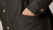 close up of man's hand in the pocket of his green jacket