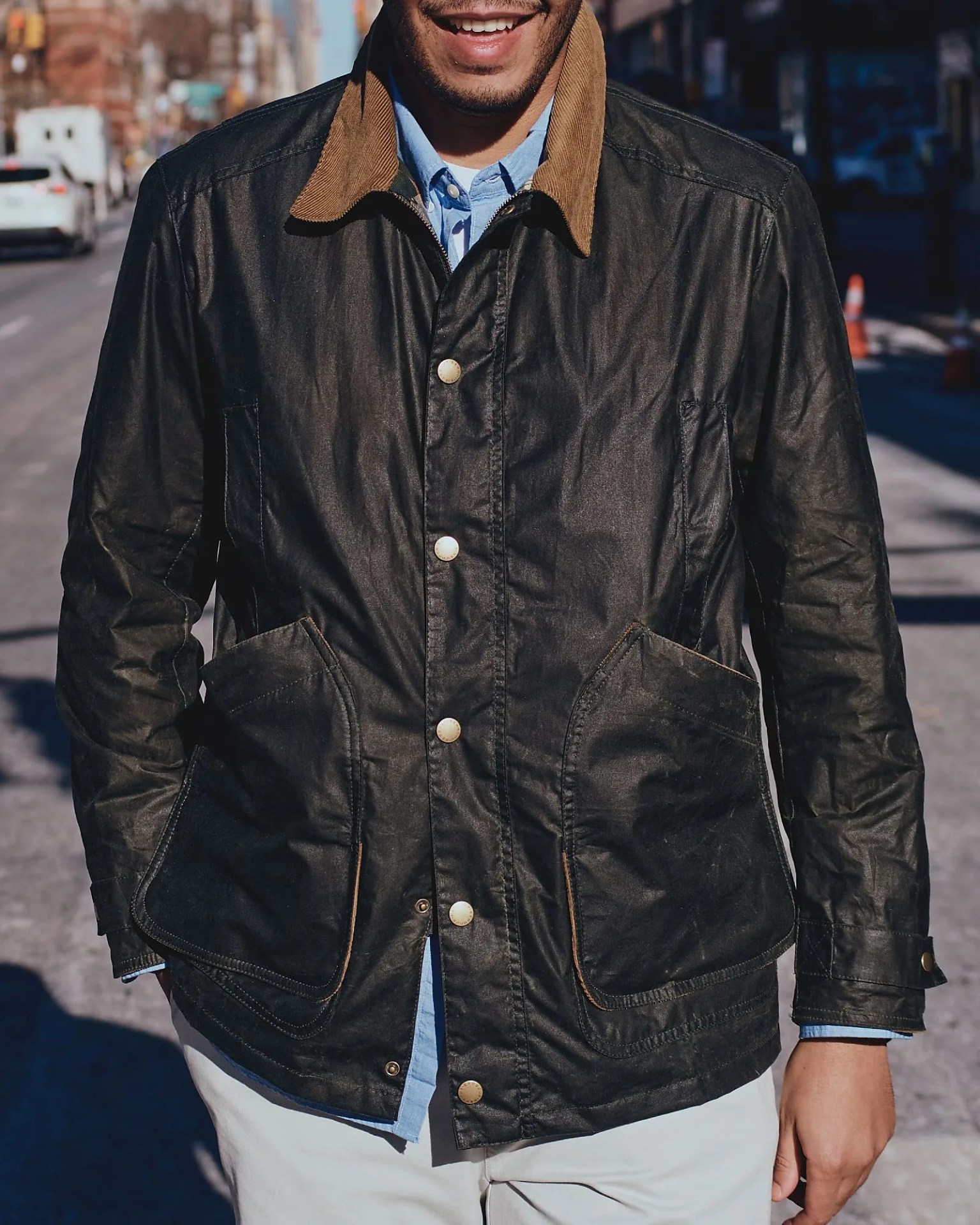 a man on the street wearing an olive waxed canvas barn coat