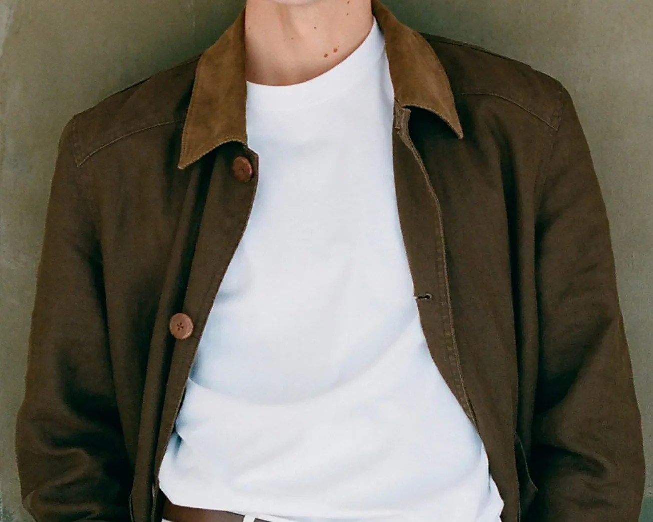 a man in a brown linen barn coat